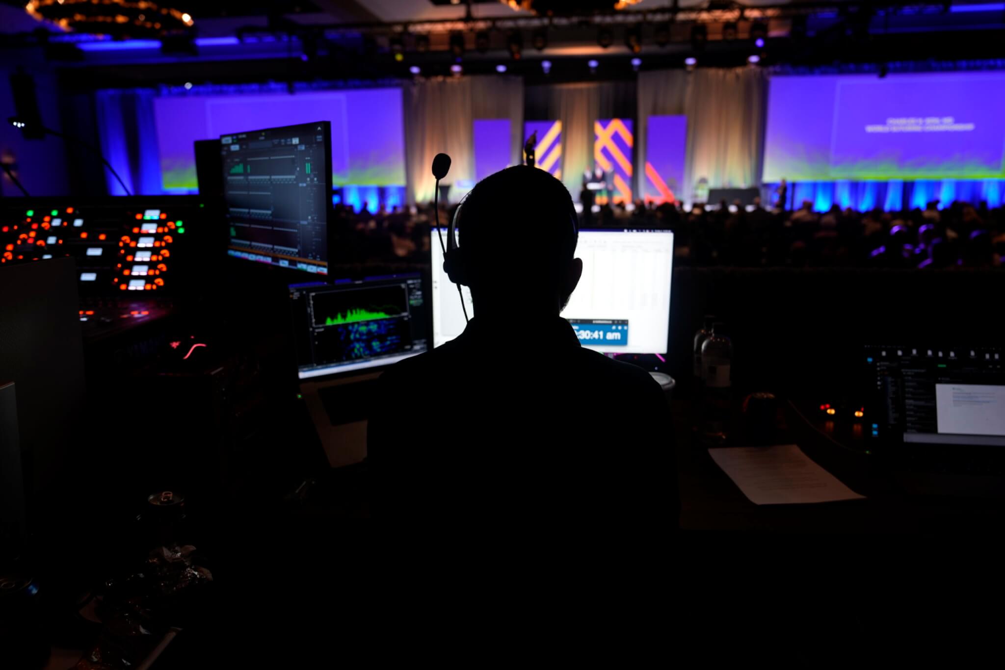 A man operating a sound booth during a live event.